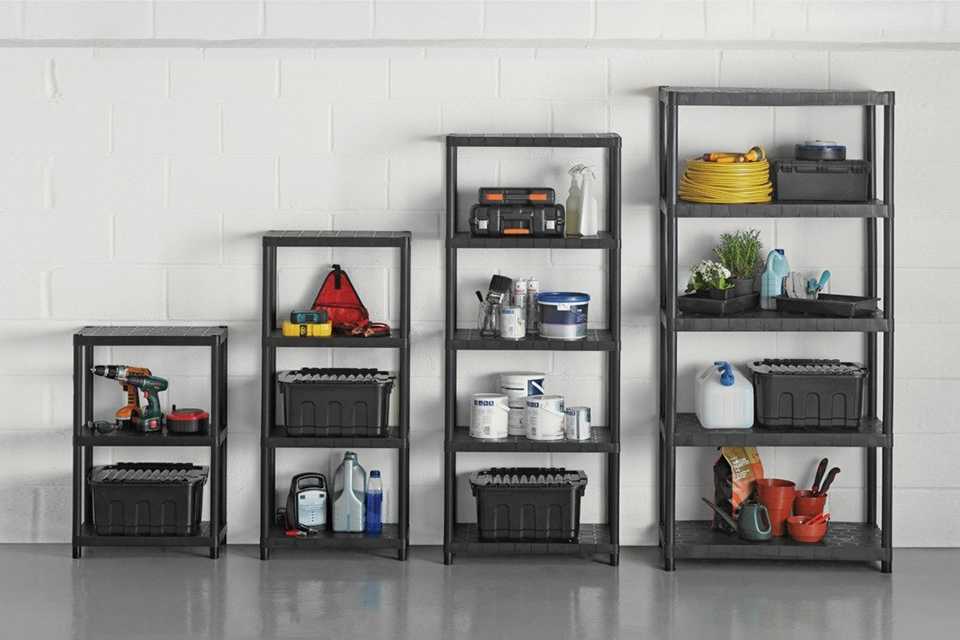 A set of 5, 4, 3, and 2 tier plastic shelving unit in a garage displaying plants and garden tools. 