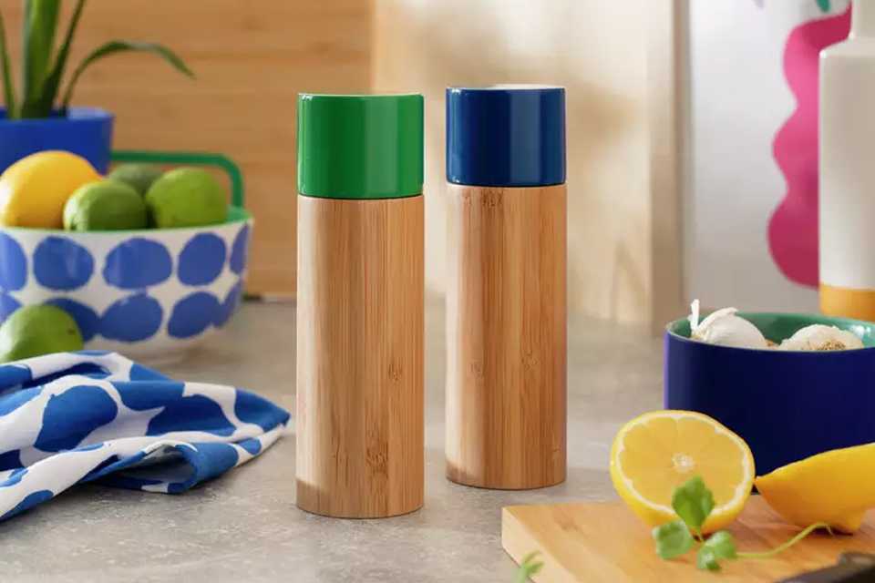 A wooden salt and pepper mill set with blue and green tops.