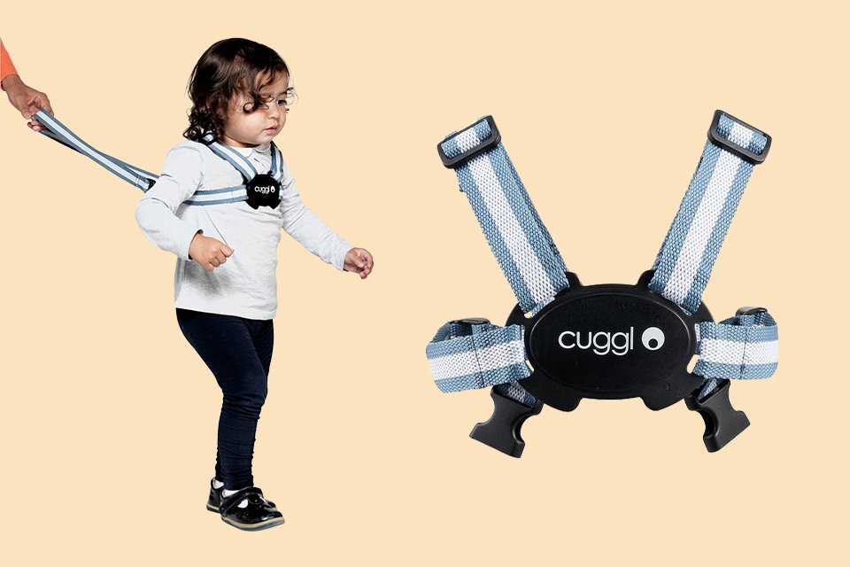 A toddler wearing a safety harness while walking.