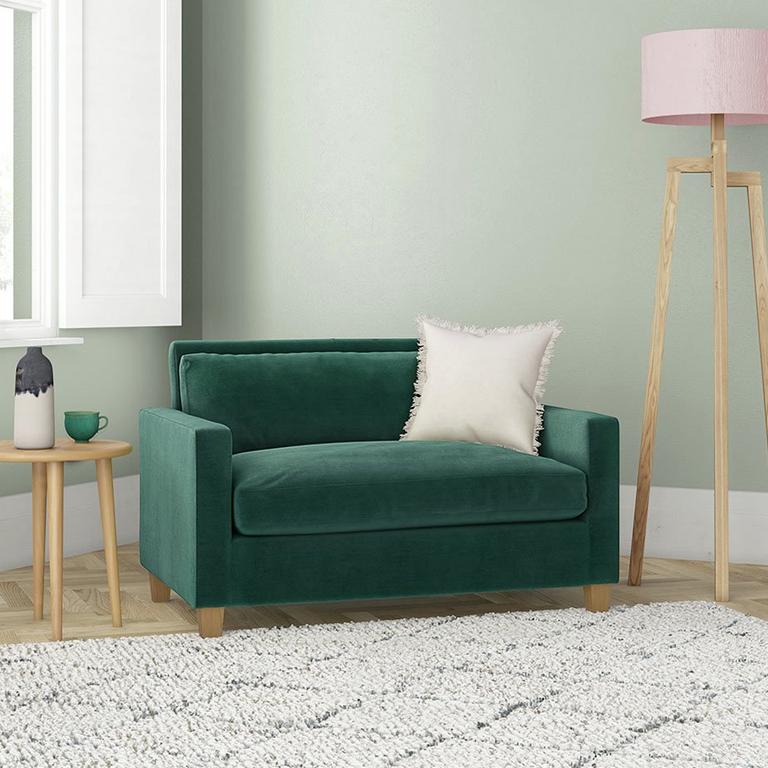 The orange Habitat Jackson velvet cuddle chair in a smart lounge.