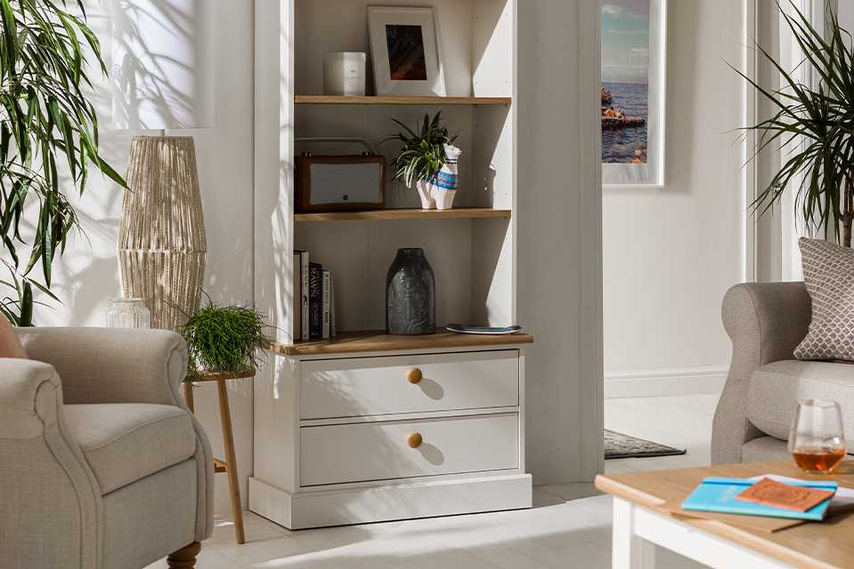 A white and natural wood bookcase unit with both shelves and drawers.