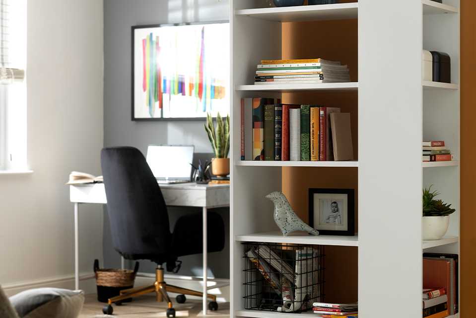 A white bookcase in a grey and orange office space.