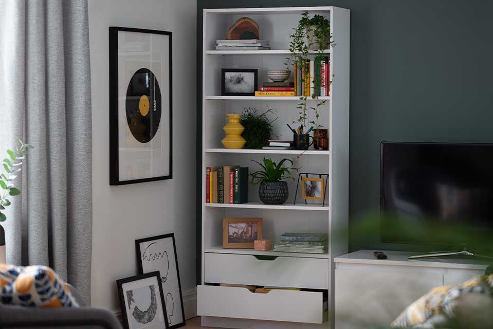 A white bookcase with both shelves and drawers for versatility.