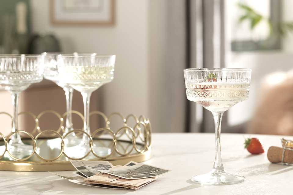 Crystal wine glasses on a mirrored gold tray.