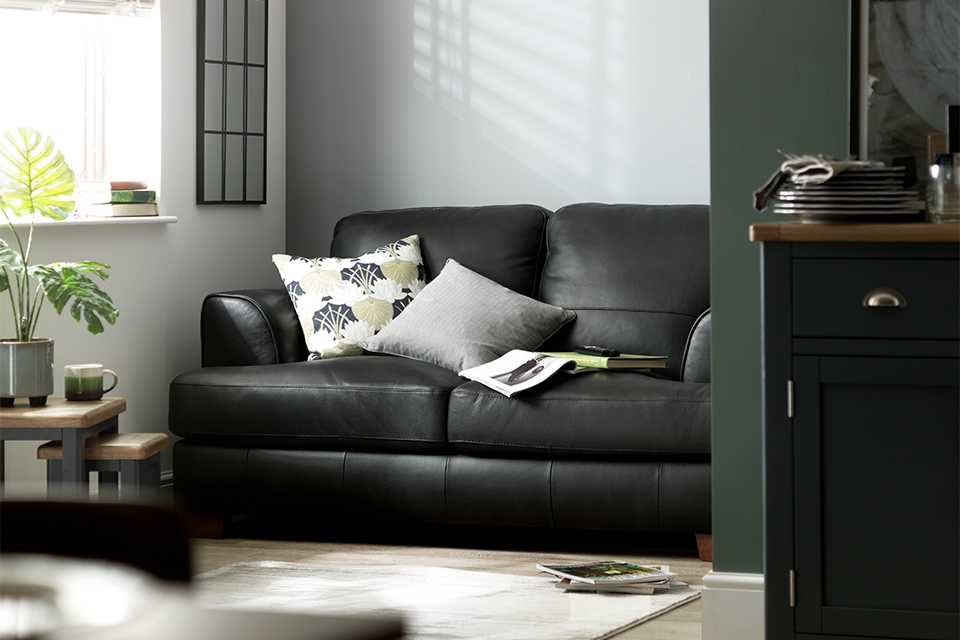 Image of black sofa with cushions in living room.