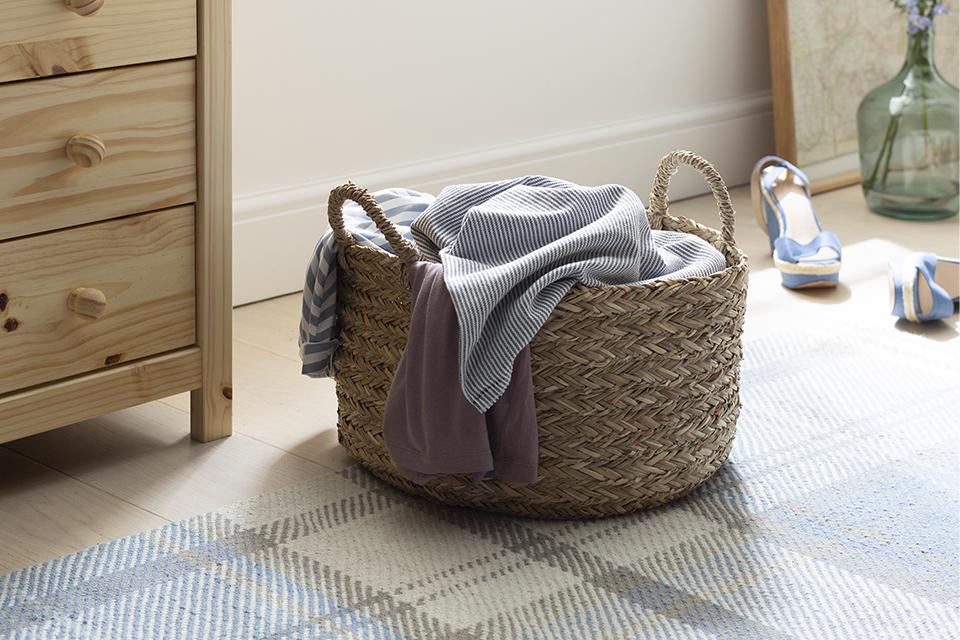 Image of a wicker basket with clothes in it.