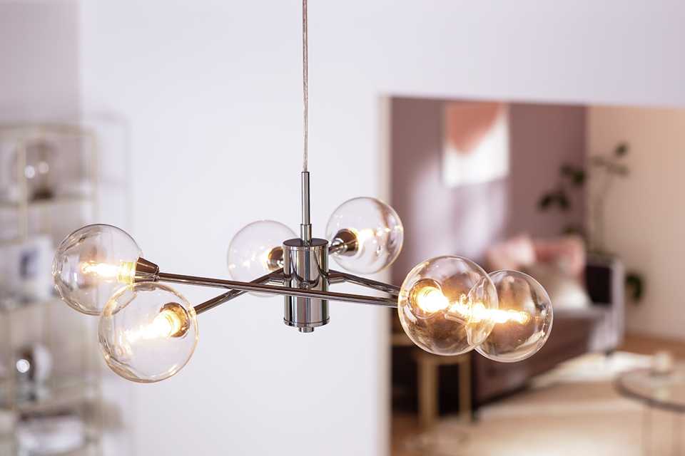 Image of a chrome pendant with six exposed bulbs.