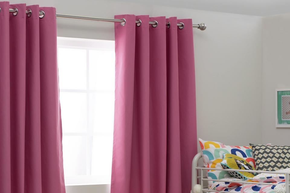 Kid's bedroom with bright pink curtains.