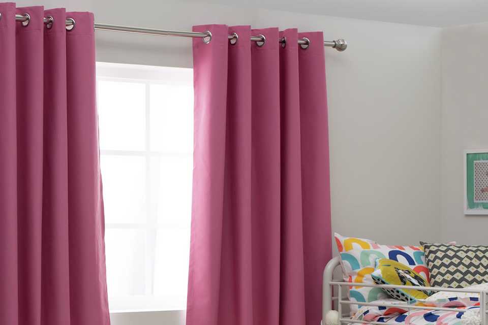 Pink curtains hanging above window.