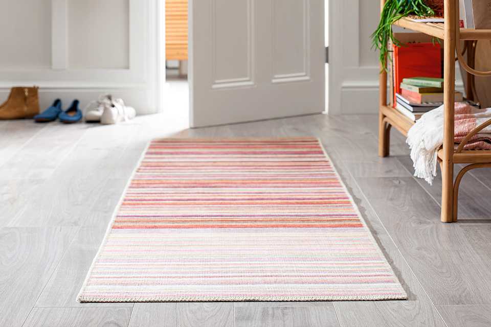 A warm-toned striped runner in a neutral hallway.