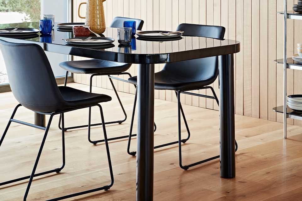 Black glossy rectangular dining table with leather dining chairs.