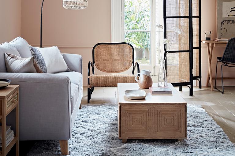 Living room with grey sofa and rattan armchair.