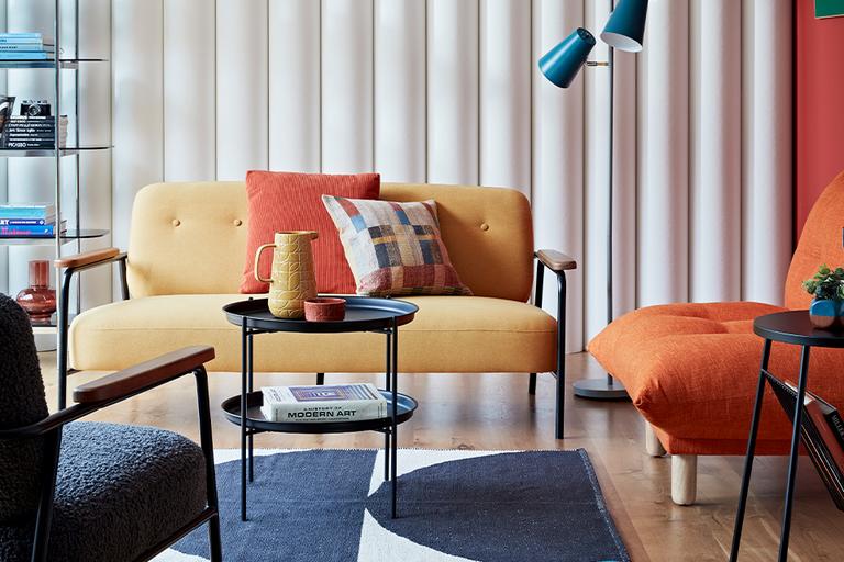 Mid century style living with yellow sofa and orange armchair.