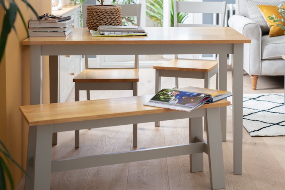 Oak and white dining table with two matching chairs and a bench.
