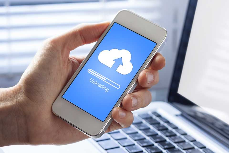 A person uploading files to the cloud storage on their mobile phone.