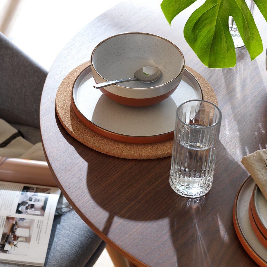 White and ochre stoneware tableware on a round dining table.