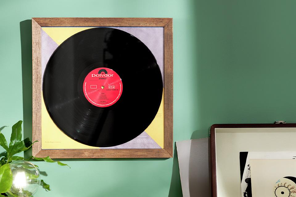A mint green wall with vinyl record wall art.