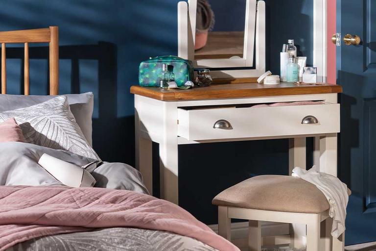 Image of blue bedroom with a white and wood top dressing table.