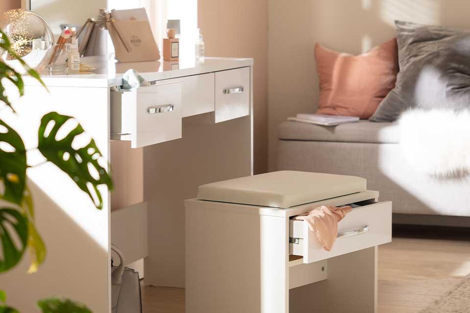 Image of a white dressing table and stool in a bedroom.