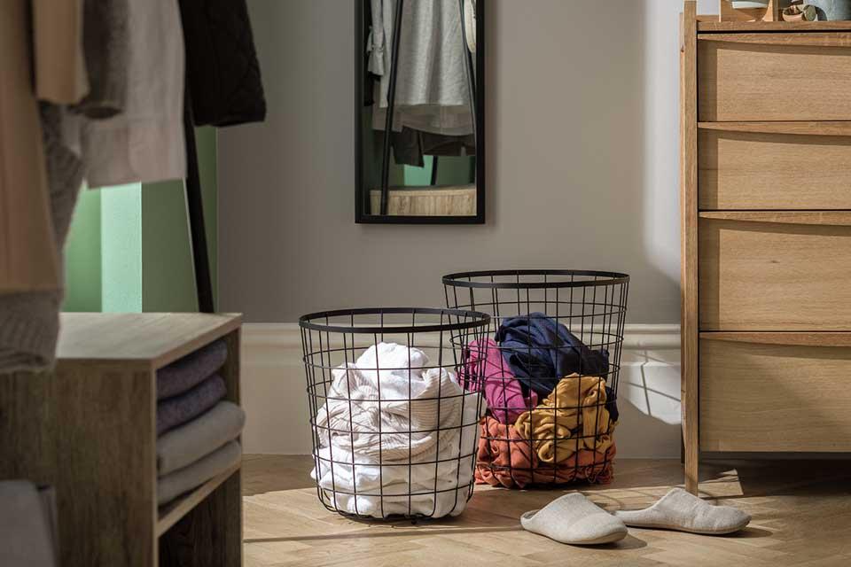 Image of two black wire baskets in a bedroom.