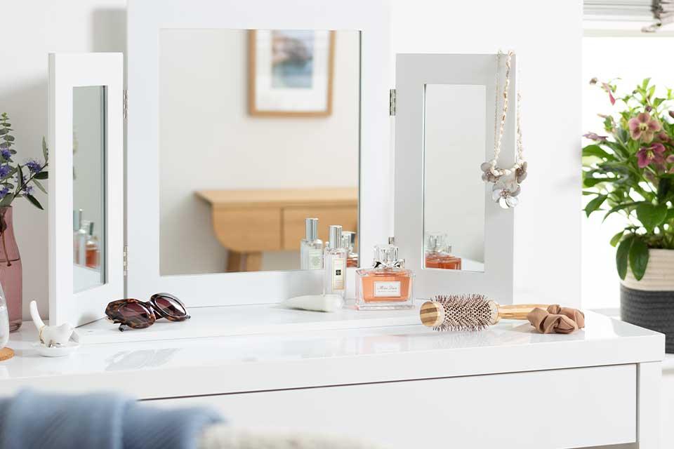 Image of a white dressing table top with a white triple dressing table mirror.