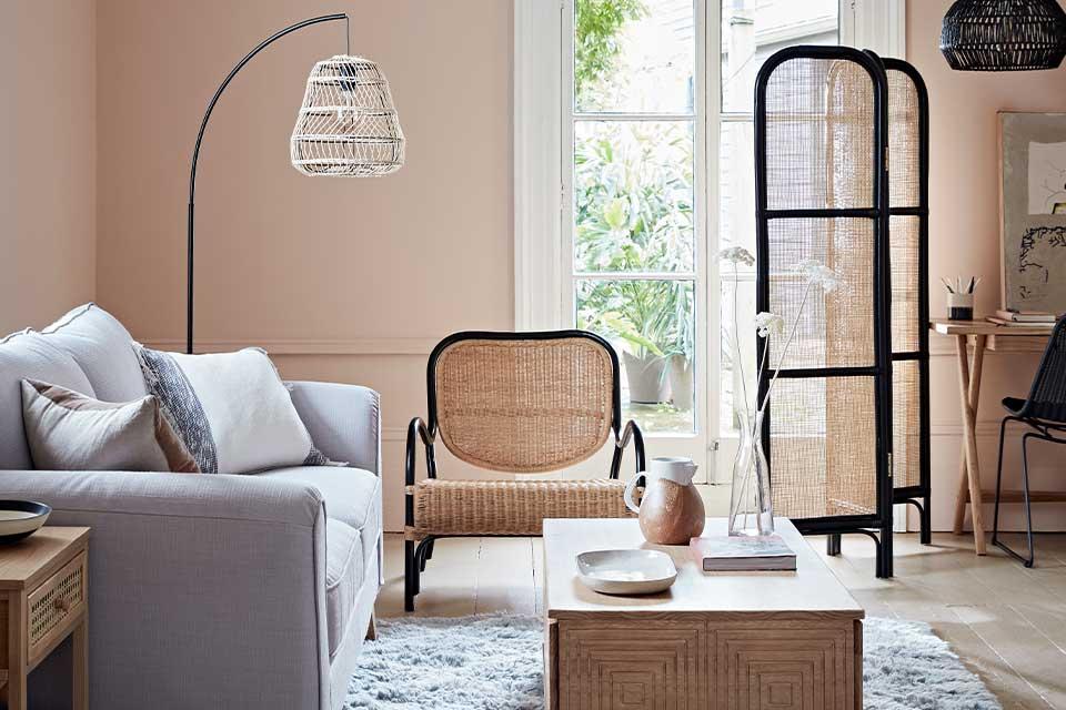 Image of a rattan room divider and chair in a living room setting.