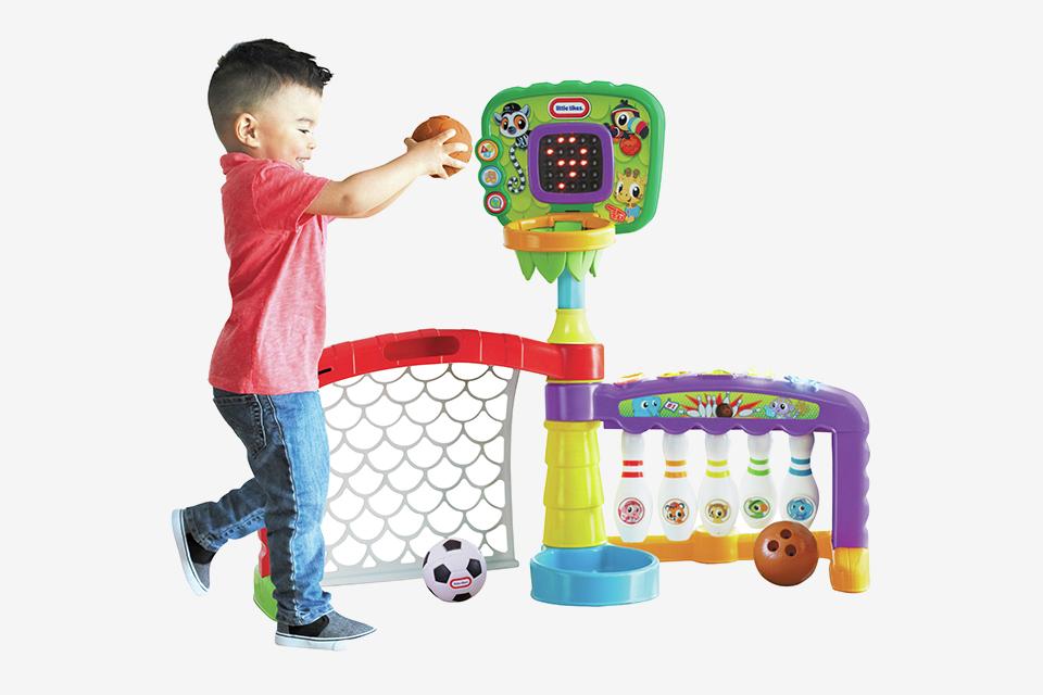 Un niño jugando con el centro de actividades deportivas 3 en 1 Little Tikes.
