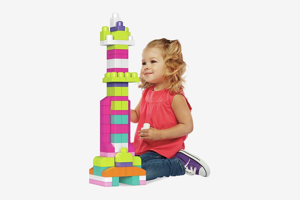 Una niña jugando con Mega Bloks 60 piezas First Builders gran bolsa de construcción en rosa.