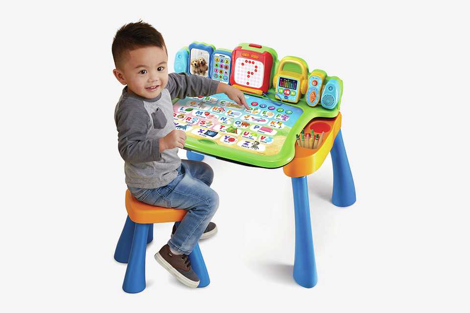A boy playing with the VTech Touch & Learn activity desk.