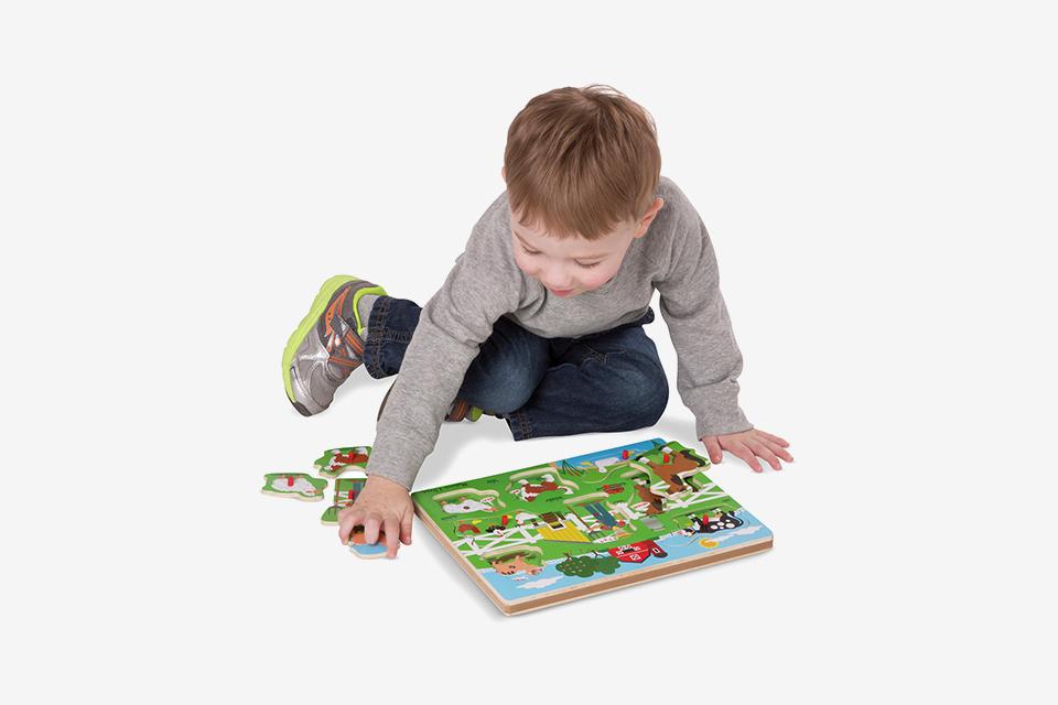 A boy playing with the Old Macdonalds Farm sound puzzle.