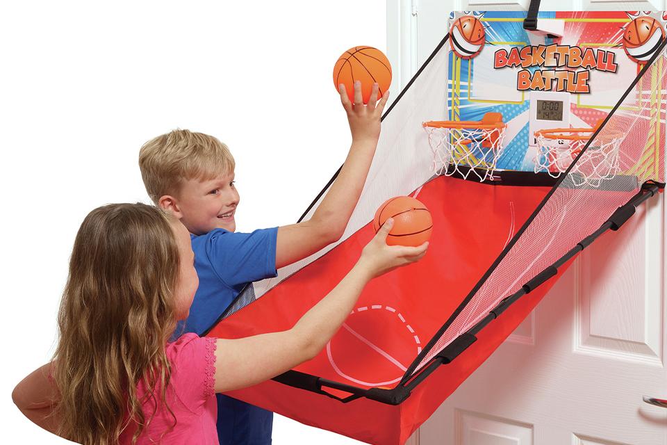 A girl and boy playing with the Chad Valley basketball battle game.