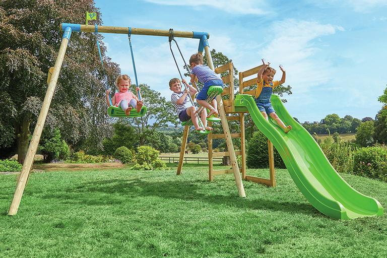  Four children playing on the TP Kite wooden kids double swing set with 8 foot wavy slide.