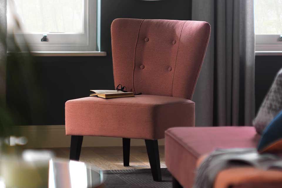 The pink Habitat Delilah fabric cocktail chair with a book and glasses resting on it.