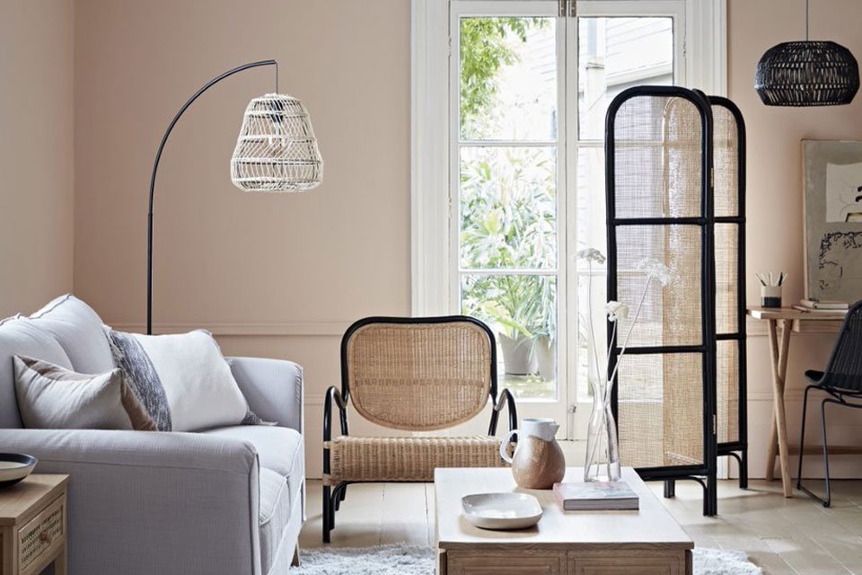Living room with grey sofa, rattan armchair and screen.