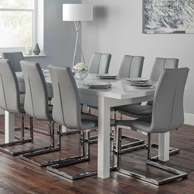 White dining table, with 8 light grey and metal dining chairs.