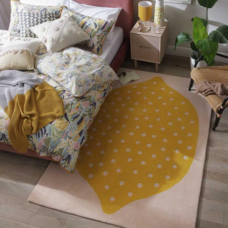 Image of a rug with a lemon on it in a bedroom.