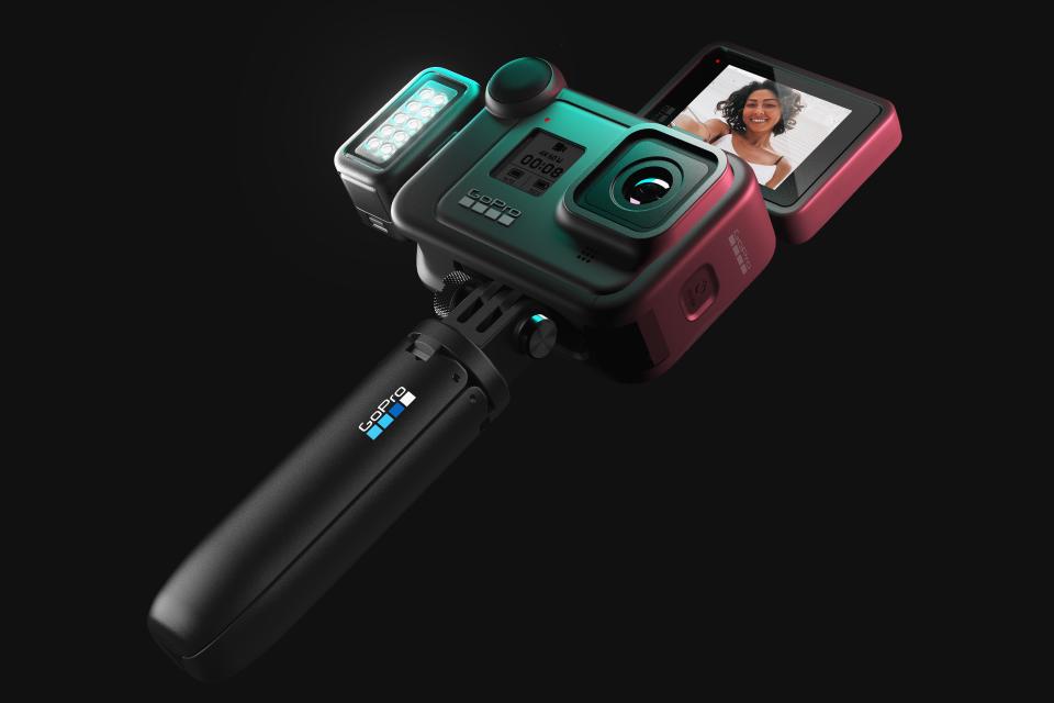 A GoPro action camera mounted on a tripod against a black background.