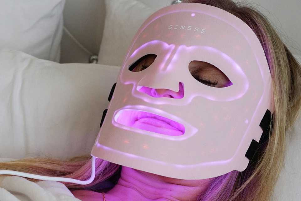 Woman wearing the Sensse Professional LED Light Therapy Facial Mask.