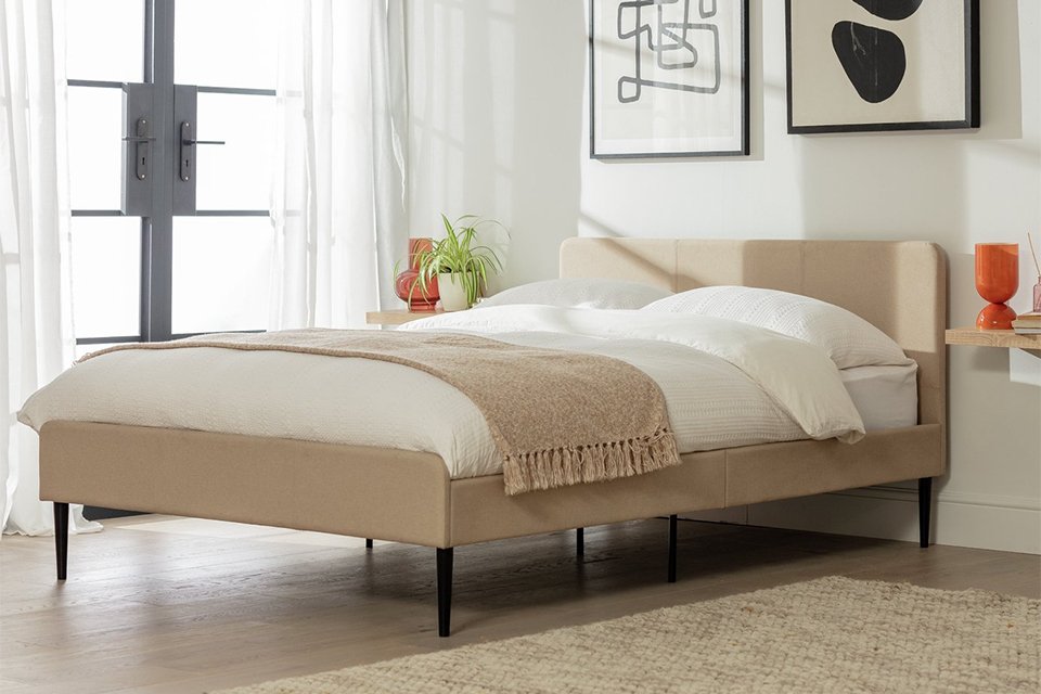 Small double bed with white bedding in bedroom.