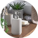 A Habitat Sandstone Effect Ceramic Soap Dispenser in natural finish on a wooden tabletop. 