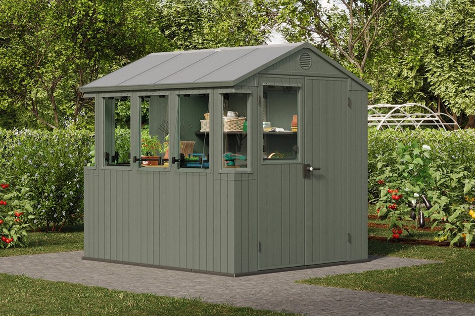 Keter Darwin potting shed in green colour placed outdoors.
