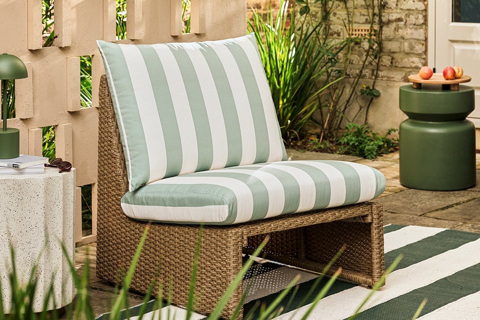 A garden chair with green stripes on its cushions.