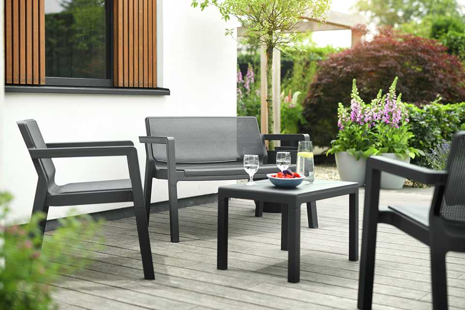 A plastic sofa, chairs and table garden furniture set.