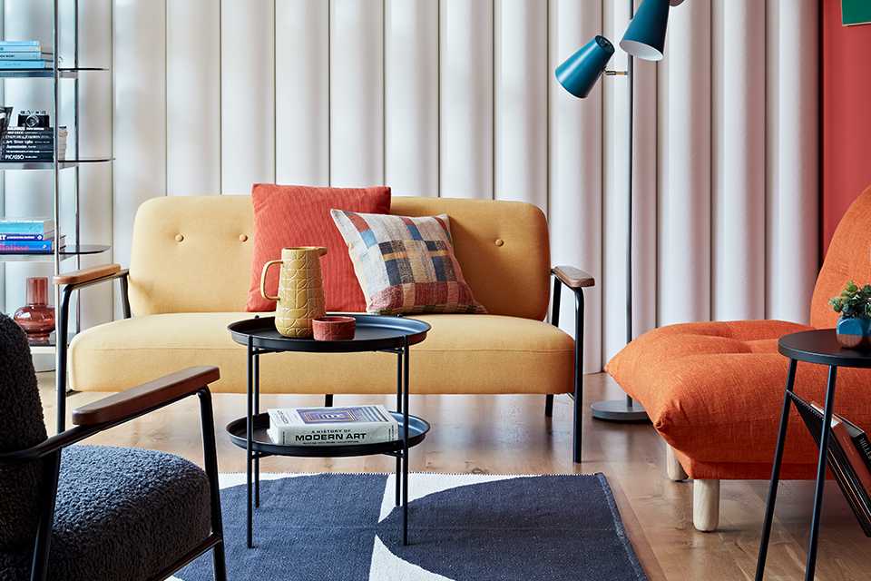 The yellow Habitat Cooper 2-seater fabric sofa in a retro-style lounge.