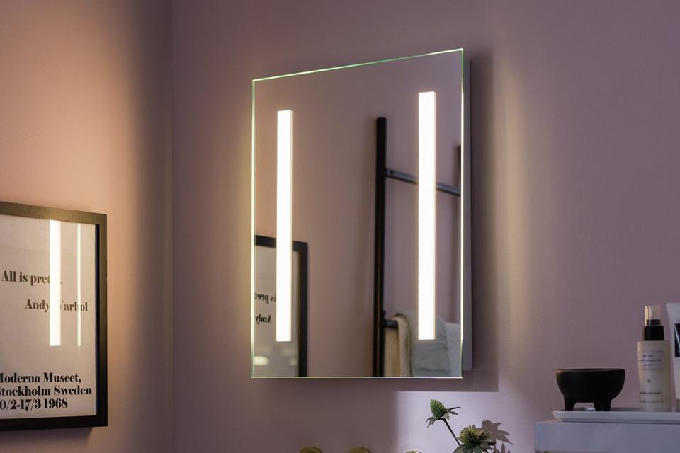 An LED lit bathroom mirror above a sink. 