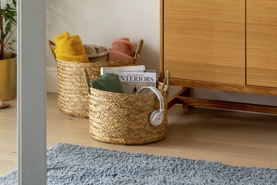 Two open woven basket sets in a room kept next to a storage unit.