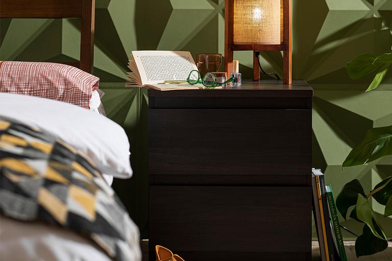 A bedside table with storage in a bedroom.