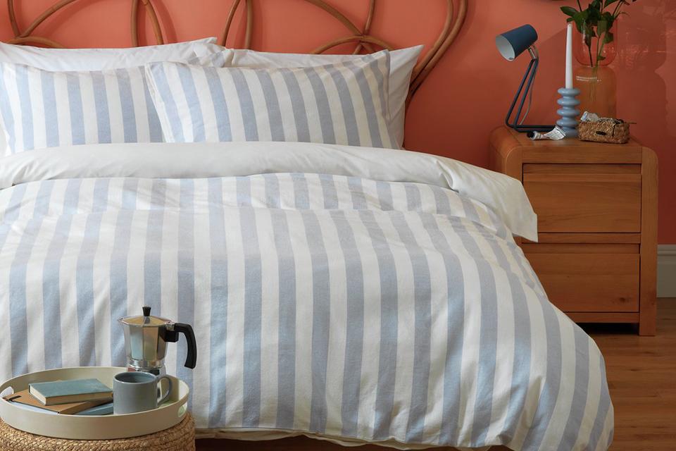 A Habitat fresh vintage stripe bedlinen on a king size bed in a bedroom.