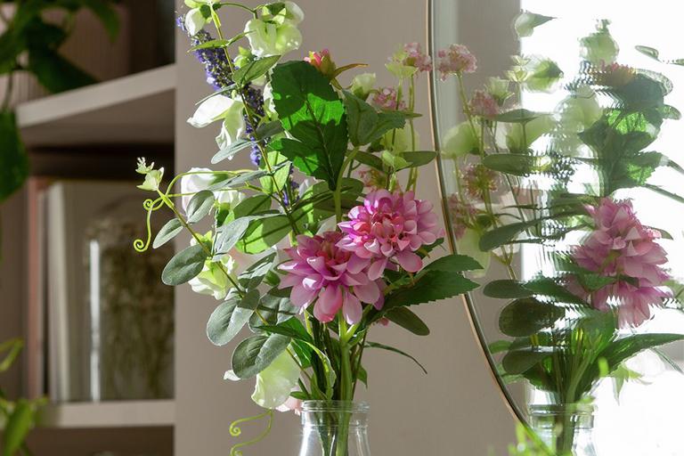 A large floral arragement in a glass vase.