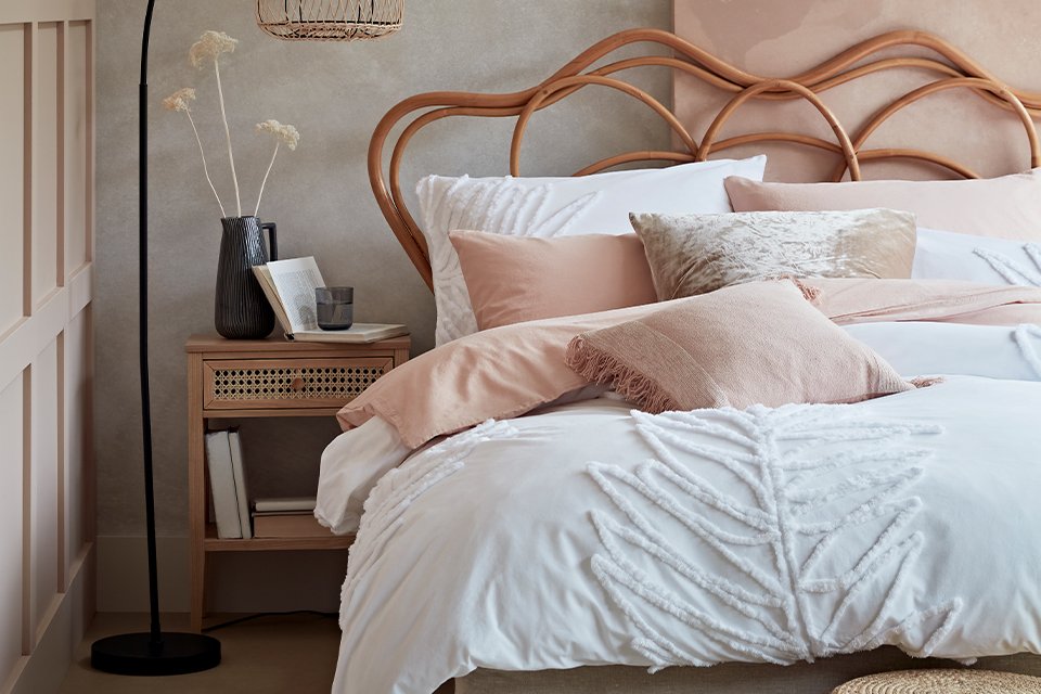 White bed next to side table with bedroom storage.